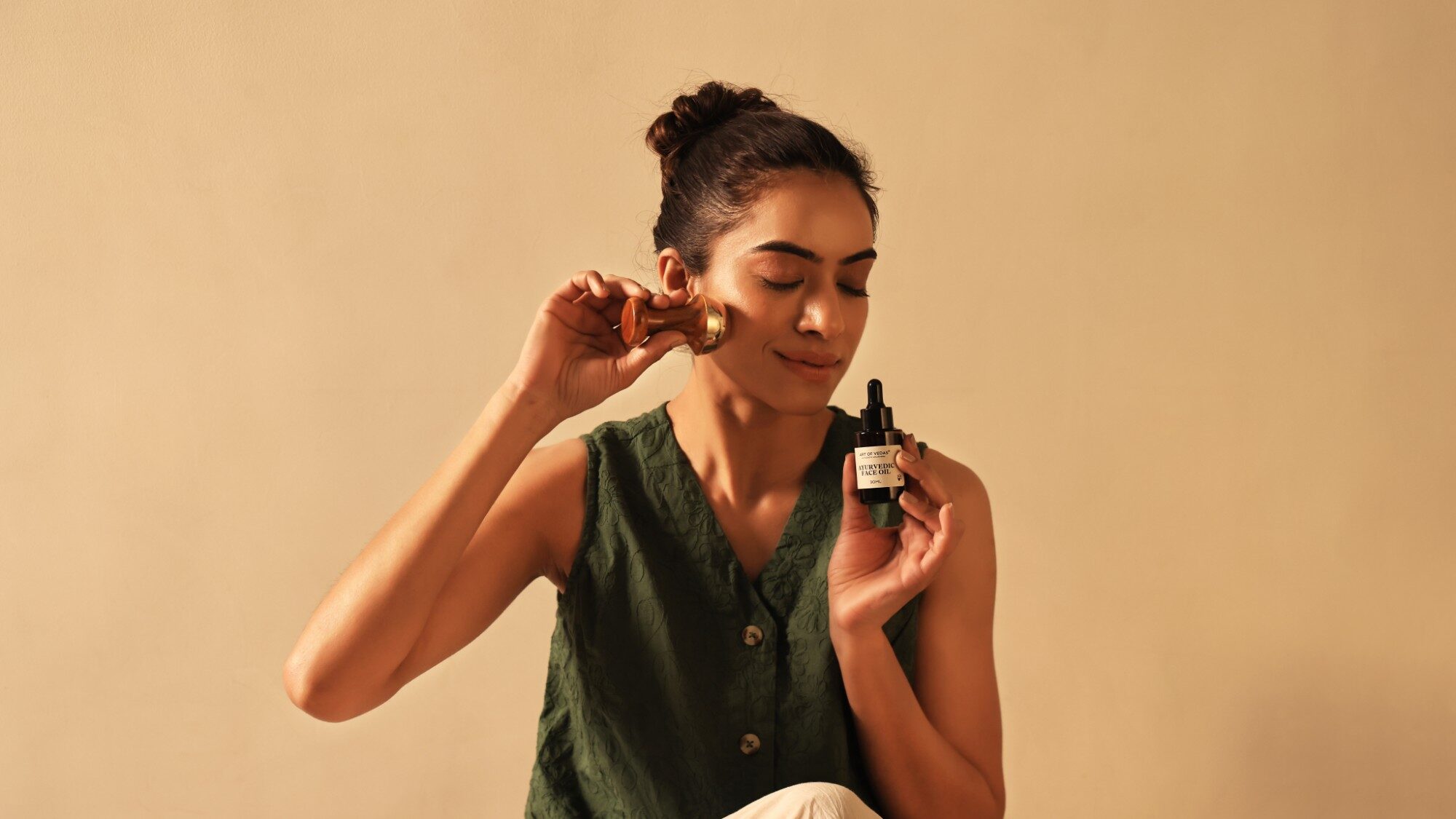 Art of Vedas Ayurvedische gezichtsolie naast een Kansa hulpmiddel voor gezichtsmassage in een dagelijks ritueel