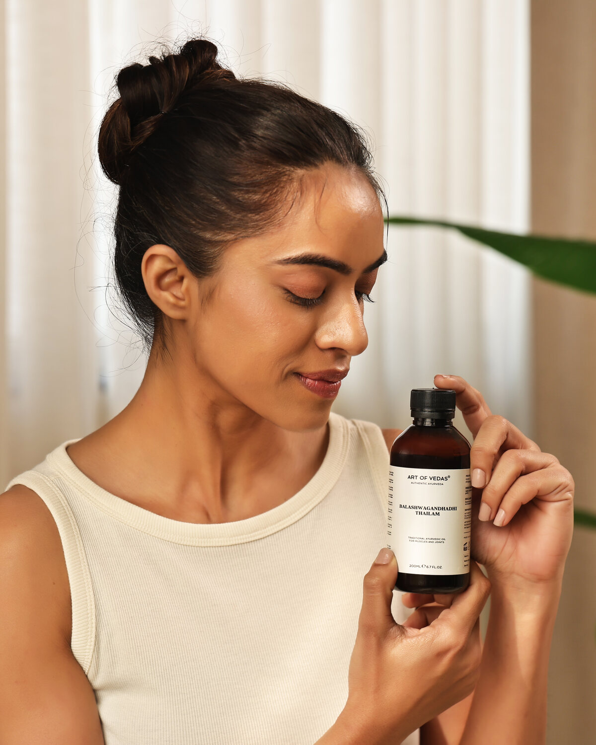 Art of Vedas model houdt Balashwagandhadhi Thailam vast